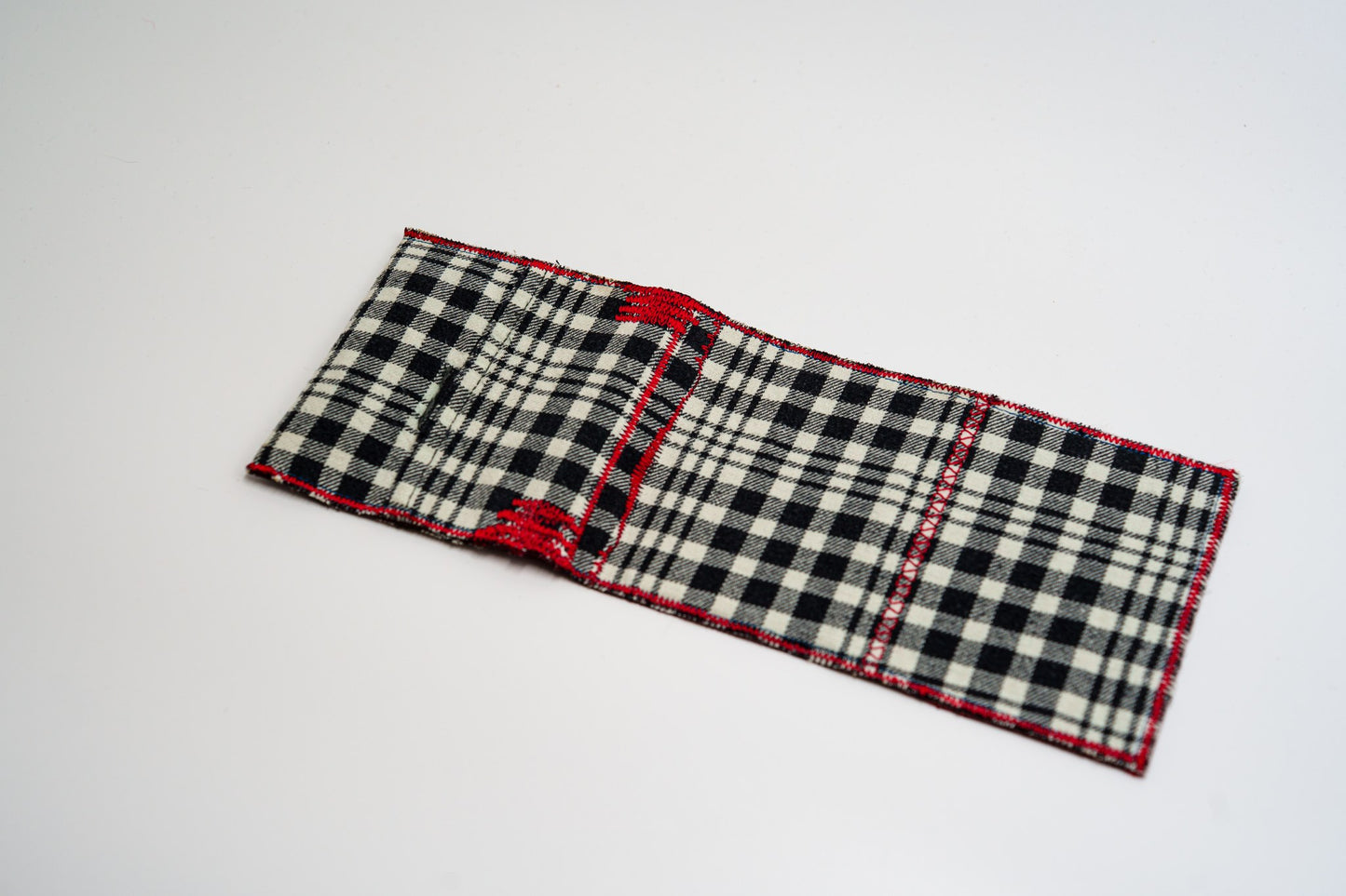 Black and pale-olive plaid exterior of a handmade wallet, laid flat — HighSew