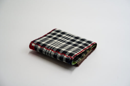 Black and pale-olive plaid wallet closed at an angle, handmade from an upcycled flannel shirt — HighSew