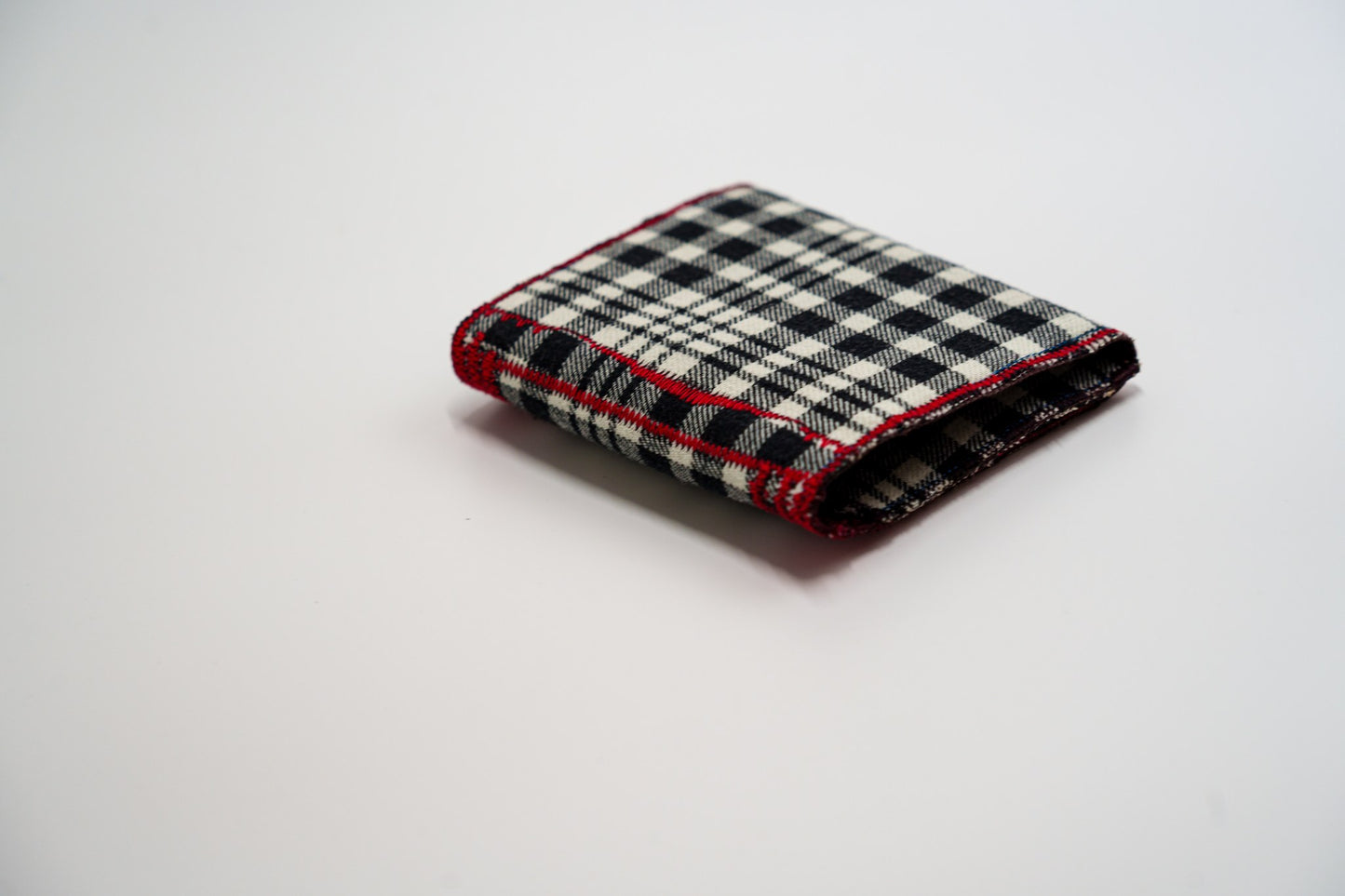 Black and pale-olive plaid wallet closed at an angle, handmade from an upcycled flannel shirt — HighSew