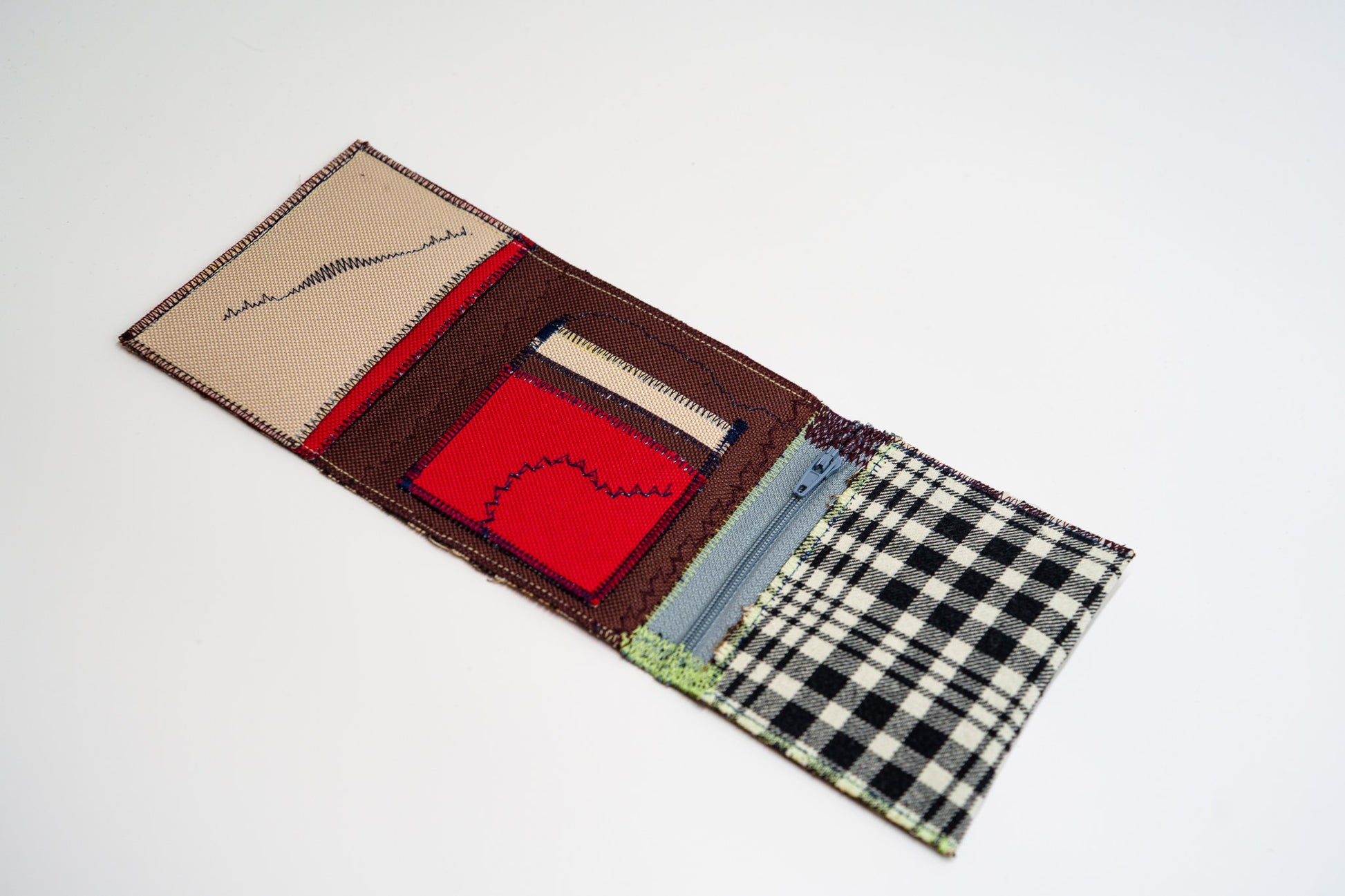 Open wallet interior with sand, red and brown panels, colored stitching and a pale grey zip — HighSew