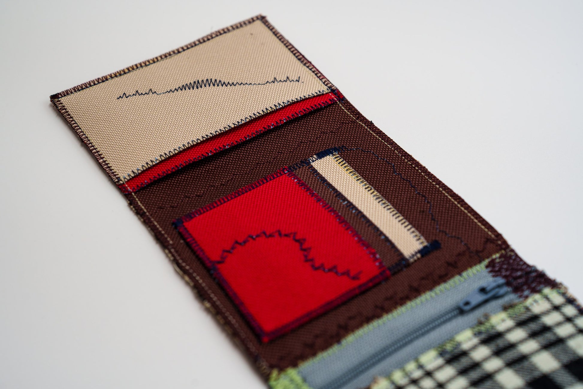Close-up of red card pocket with blue arc stitching and sand panel, from an upcycled flannel shirt — HighSew
