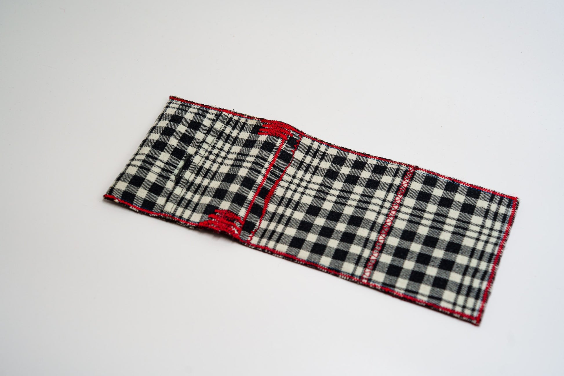 Black and pale-olive plaid exterior of a handmade wallet, laid flat — HighSew