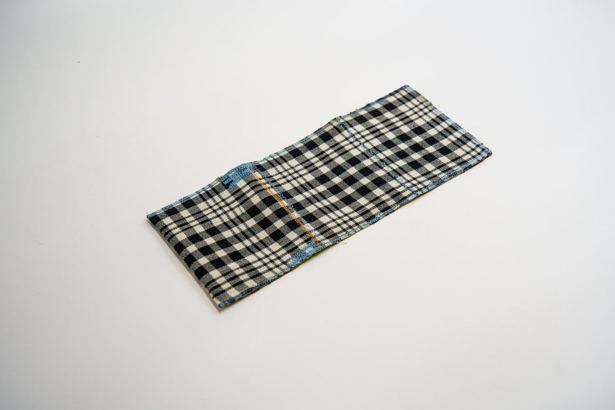 Black and pale-olive plaid exterior of a one-of-a-kind wallet, laid flat — HighSew