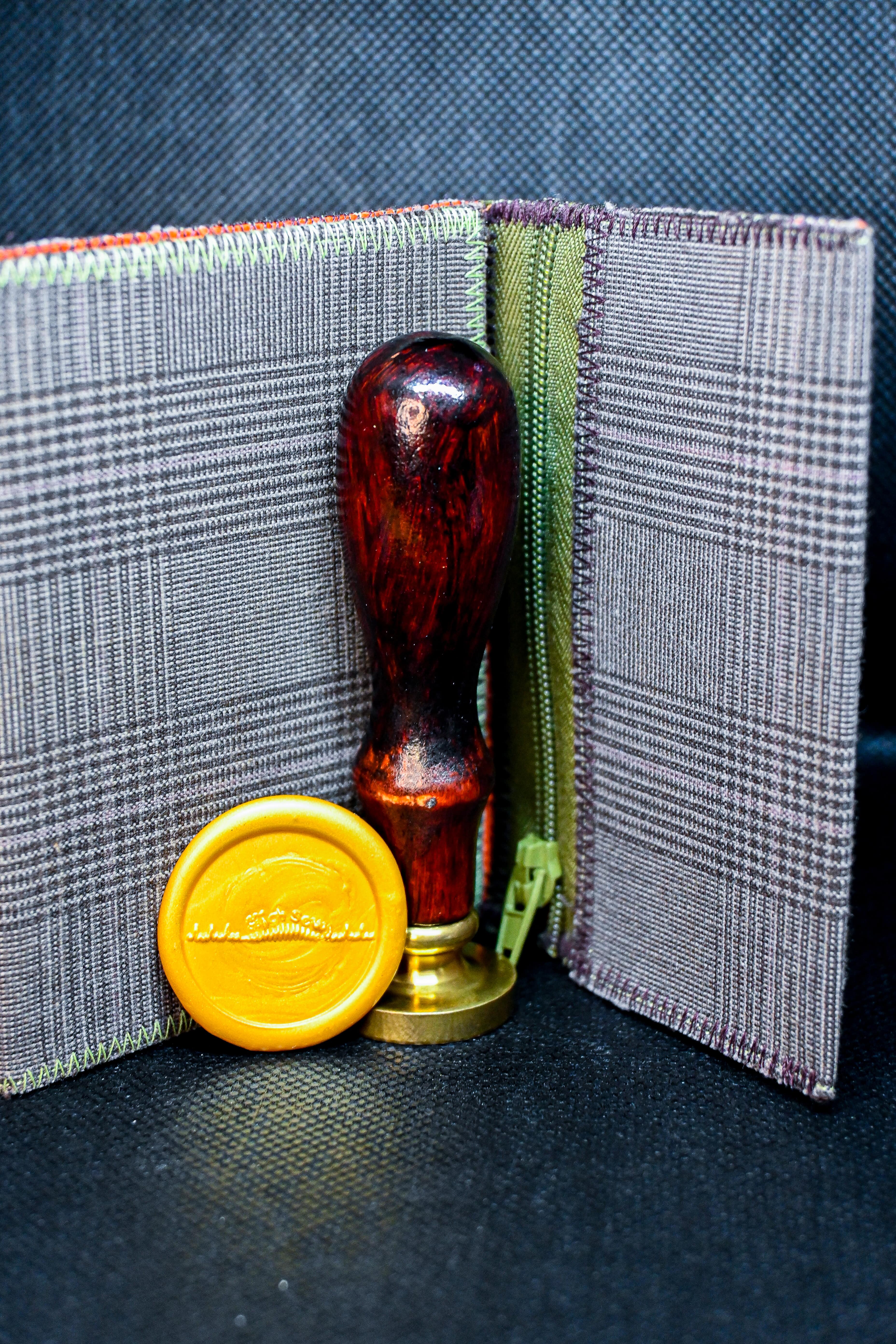 A one-of-a-kind wallet called "Drink & Evening" was made by Highsew. It is made of recycled fabric combined with new, strong fabric. It is really colorful and cool. In front of the wallet, there is a Wax Seal Stamp with the "Highsew" logo.