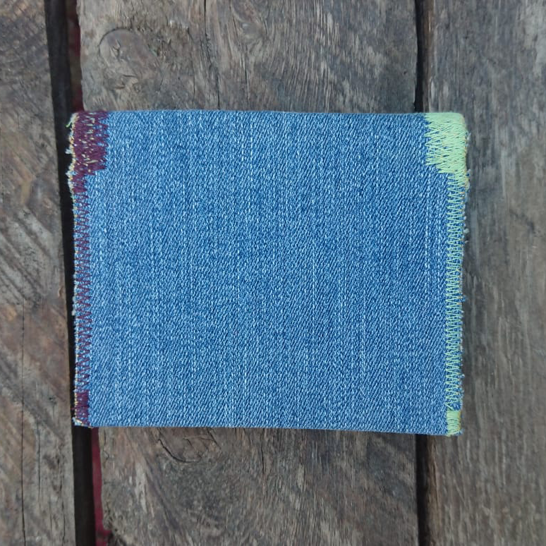 A one-of-a-kind wallet called "Purple Green Stitch Jeans" is made by Highsew. It is made of recycled jeans fabric combined with new, strong fabric. foldable.