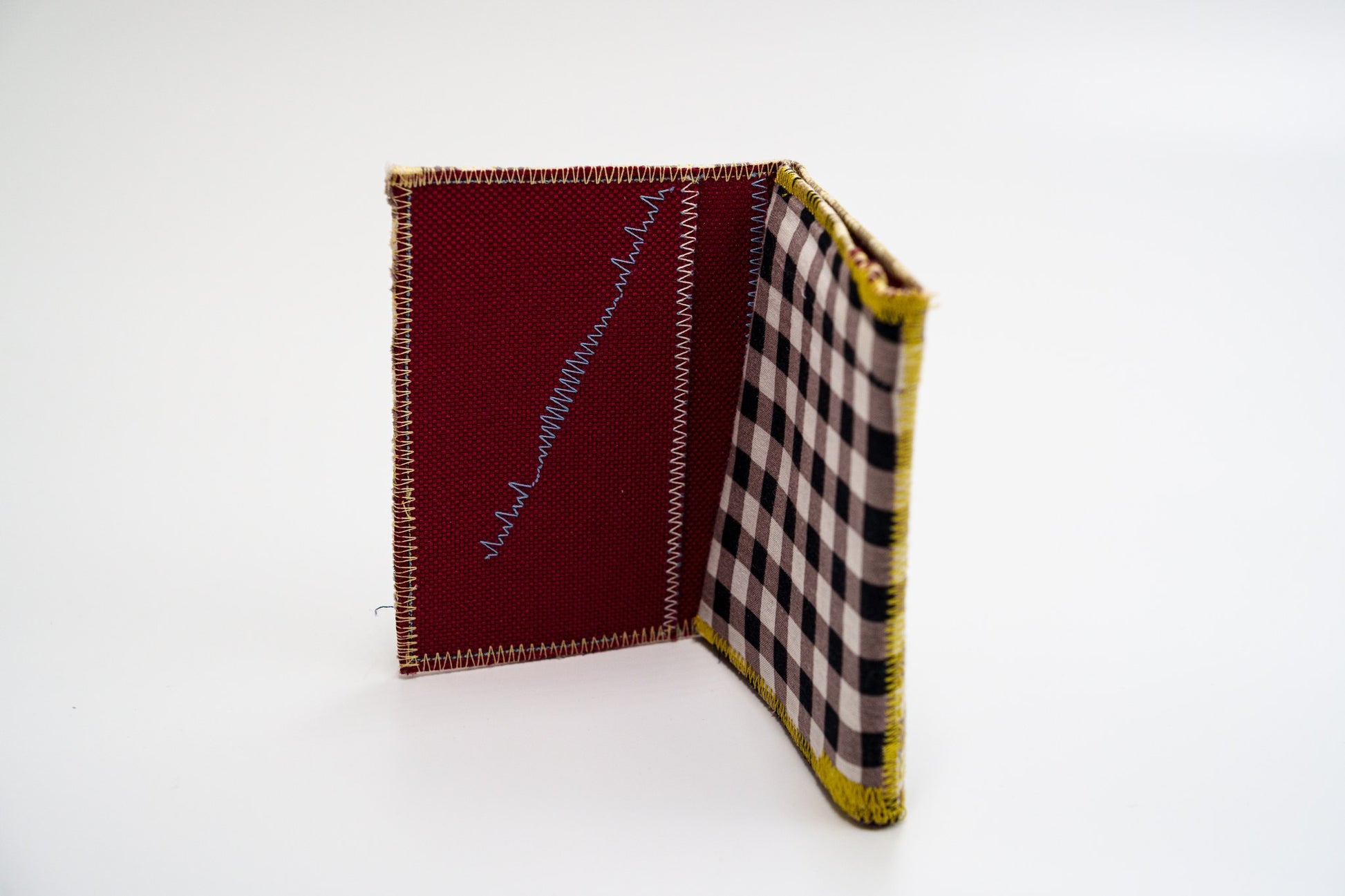 Upcycled checkered wallet standing open, red interior — HighSew