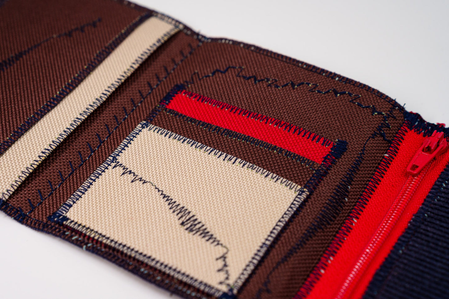 Close-up of wallet interior — brown and sand Cordura card slots with blue signature stitch and red zip — HighSew
