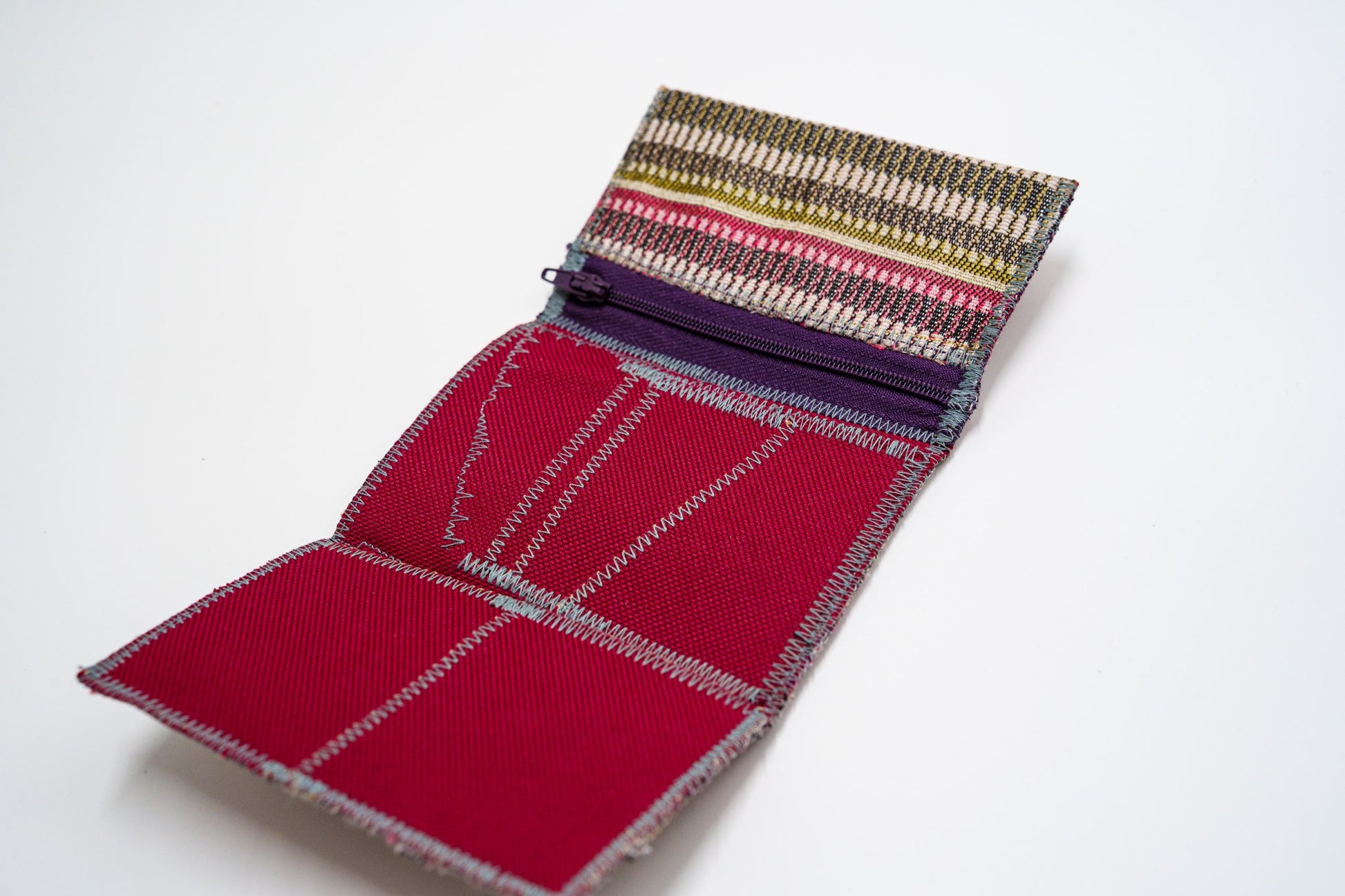 Open wallet interior in deep red with zigzag stitching and purple zip pocket — HighSew