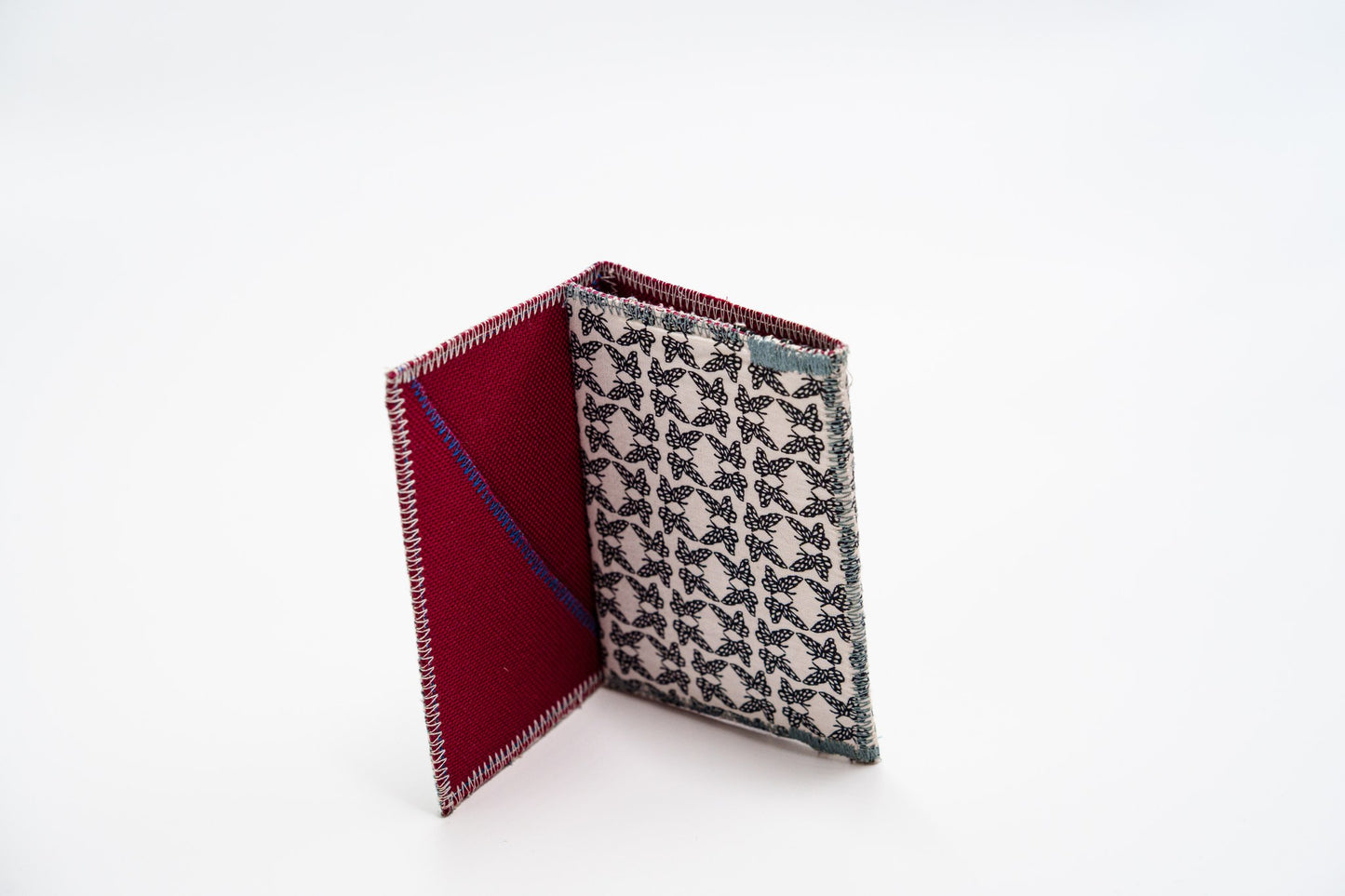 Upcycled butterfly-print wallet standing open, red interior — HighSew