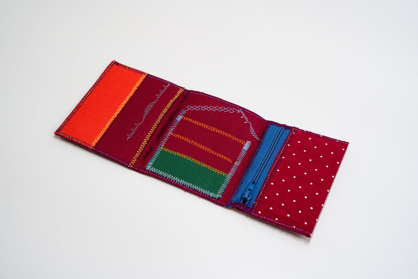 Open wallet interior with orange, green and red panels, colored zigzag stitching and blue zip — HighSew