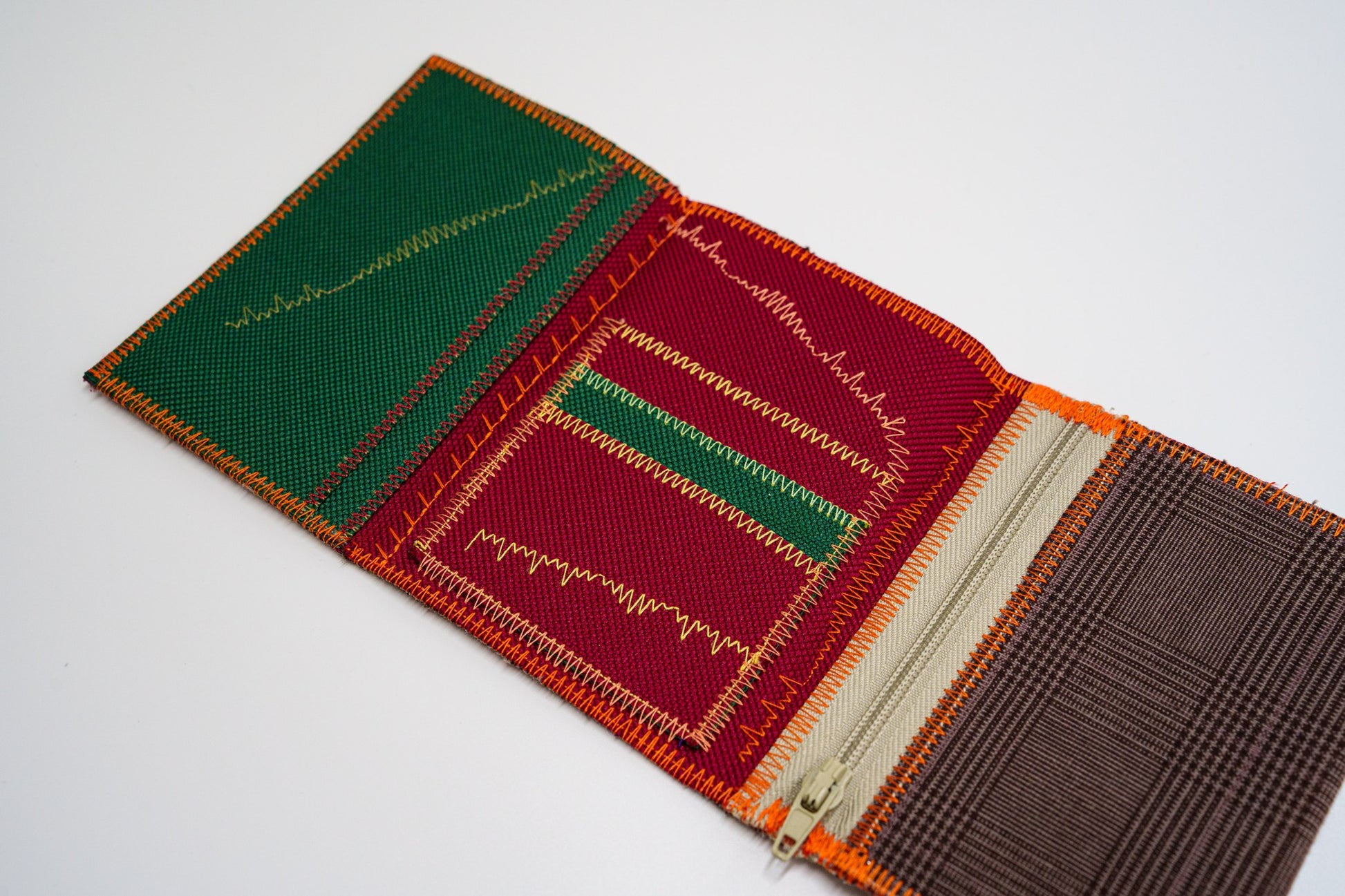 Open wallet interior with green and red panels, colored zigzag stitching and cream zip — HighSew