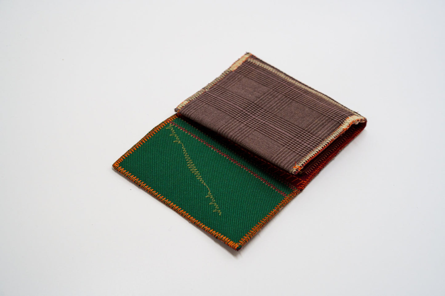 Brown plaid wallet open at an angle with green interior peek — HighSew