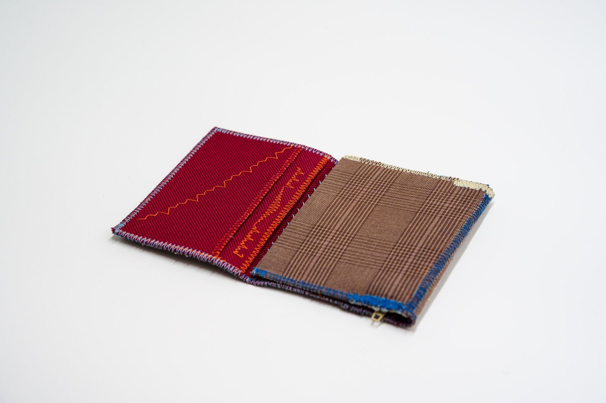 Upcycled wallet half open, brown exterior meeting red interior — HighSew