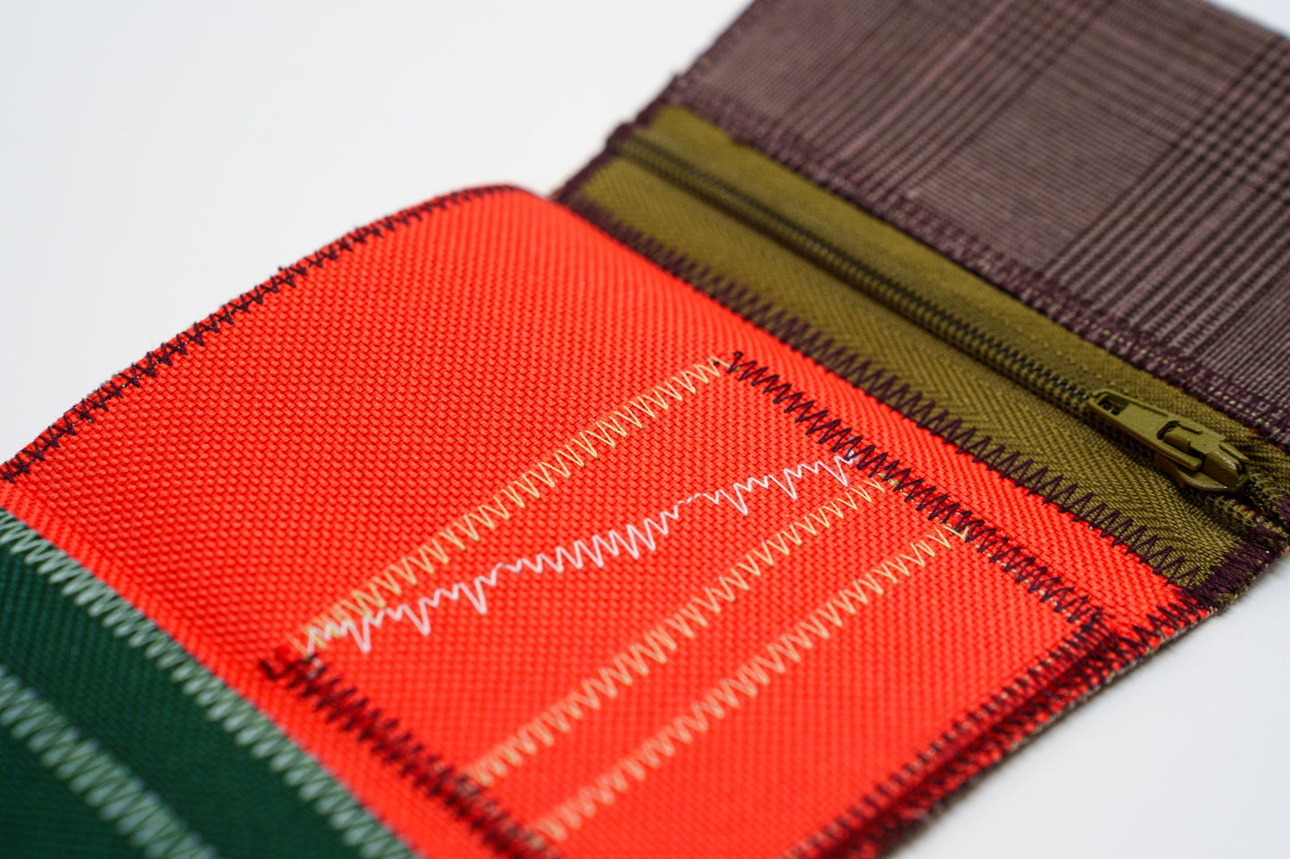 Close-up of orange-red wallet interior with zigzag stitching and khaki zip — HighSew