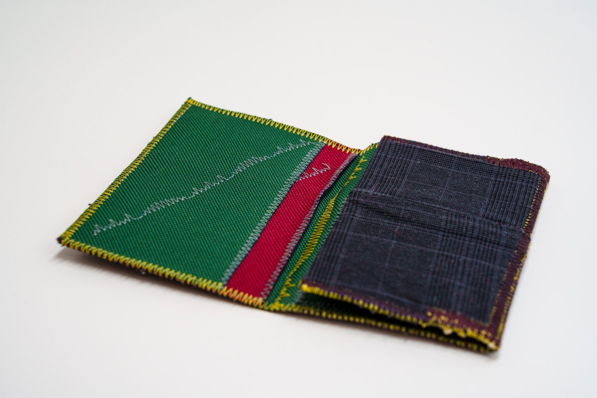 Wallet open at an angle showing green interior and dark plaid exterior — HighSew