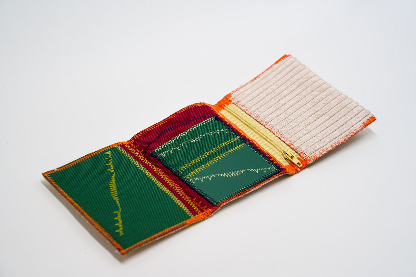 Open wallet interior in green and red with yellow zip and cream ribbed exterior — HighSew