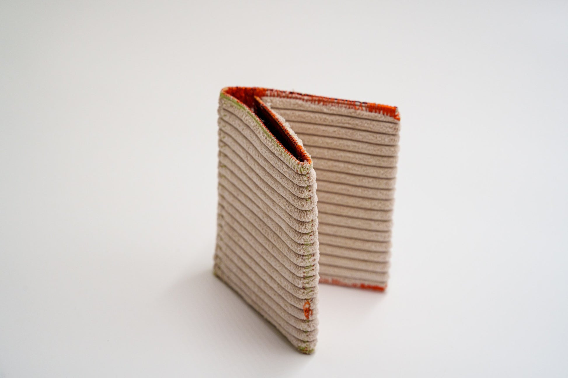 Upcycled cream ribbed wallet standing folded — HighSew