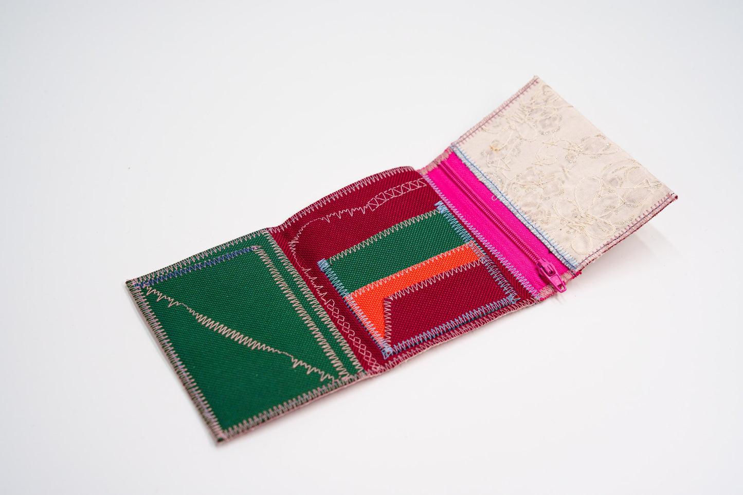 Open wallet interior in green, red and orange with colored stitching and pink zip — HighSew