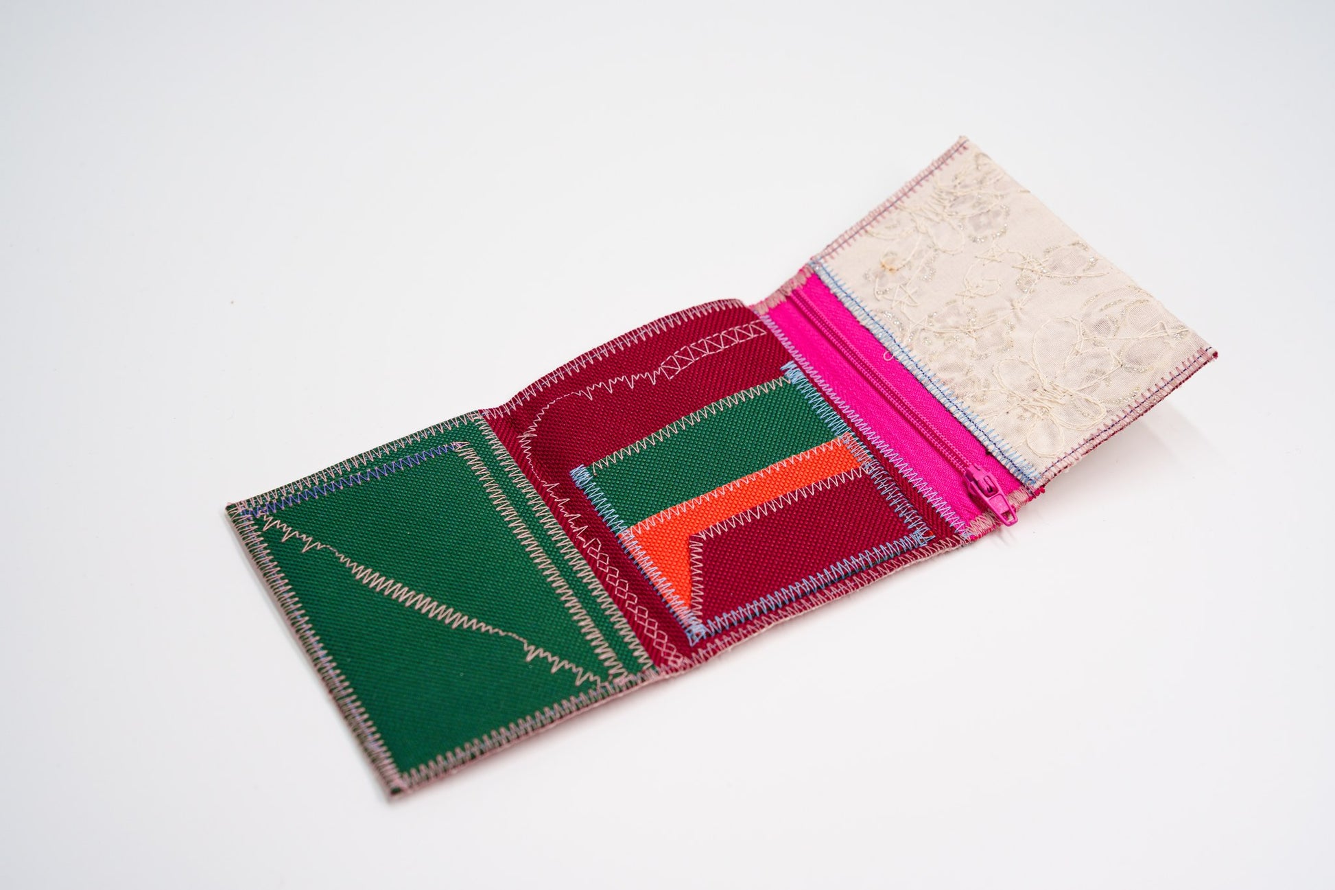 Open wallet interior in green, red and orange with colored stitching and pink zip — HighSew