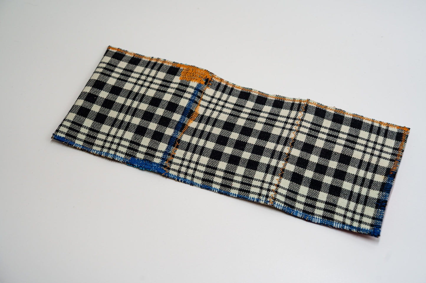 Black and pale-green plaid exterior of a one-of-a-kind wallet, laid flat — HighSew