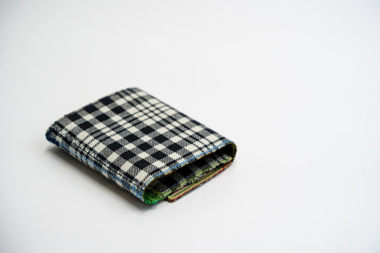 Black and pale-olive plaid flannel wallet, folded closed at an angle, handmade from an upcycled shirt — HighSew