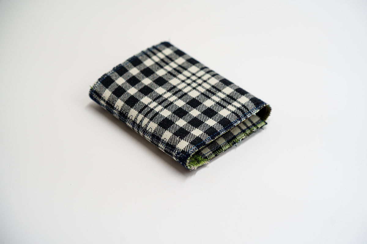 Black and pale-olive plaid wallet closed at an angle, handmade from an upcycled flannel shirt — HighSew
