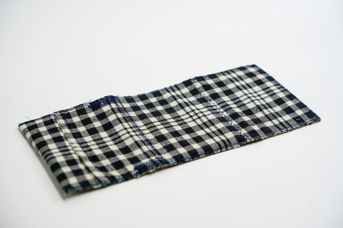 Black and pale-olive plaid exterior of a handmade wallet, laid flat — HighSew