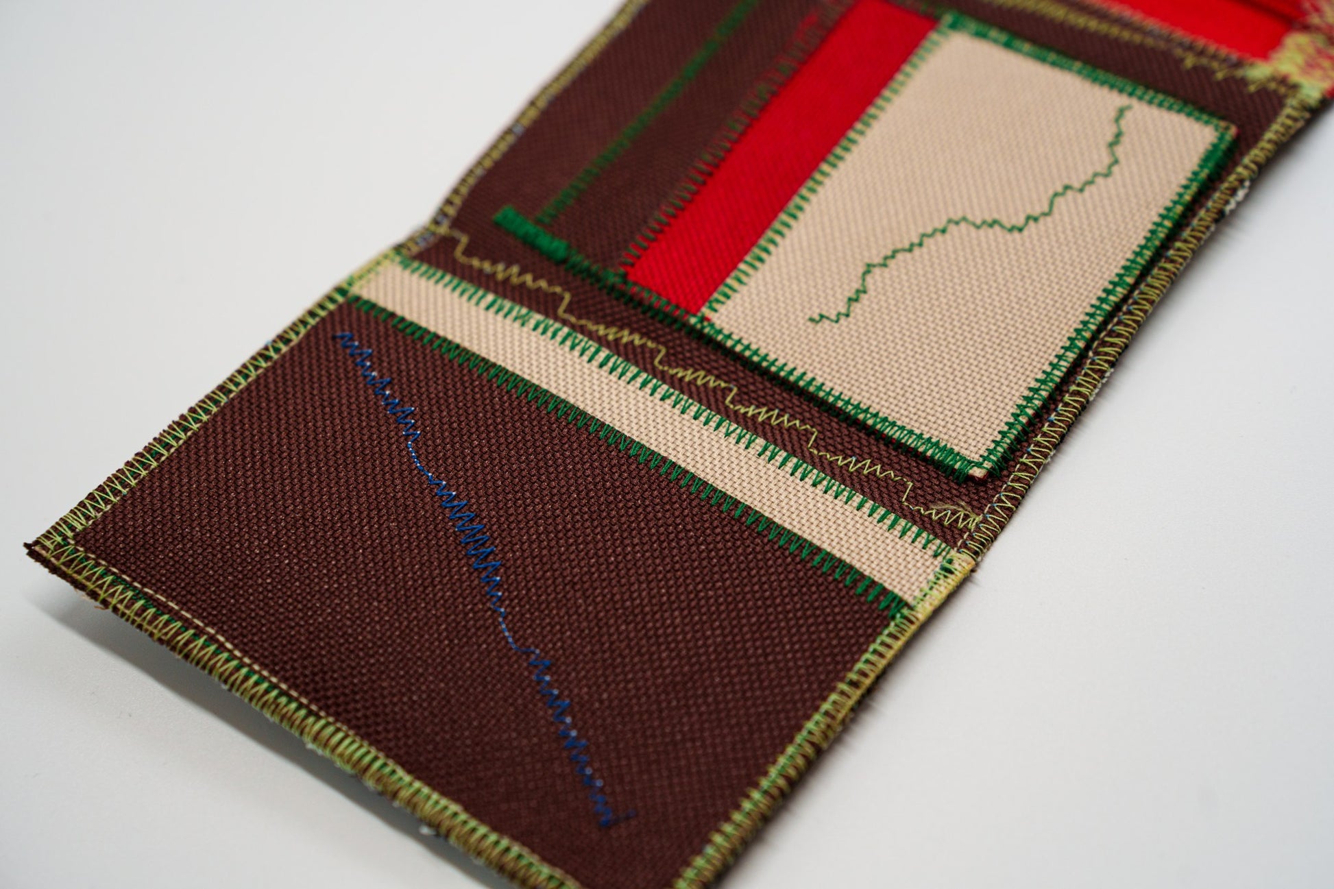 Close-up of the brown interior panel with the brand signature stitch in blue zigzag