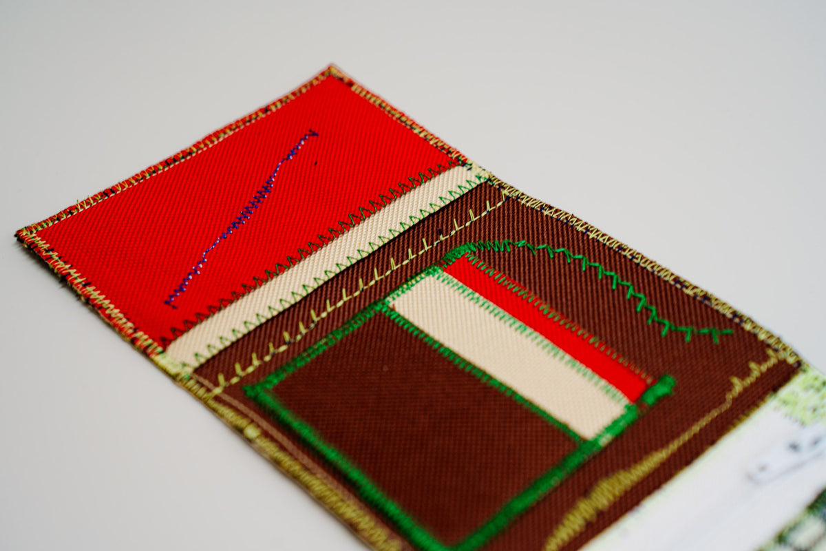 Close-up of a red interior card slot crossed by the brand signature stitch in blue — HighSew