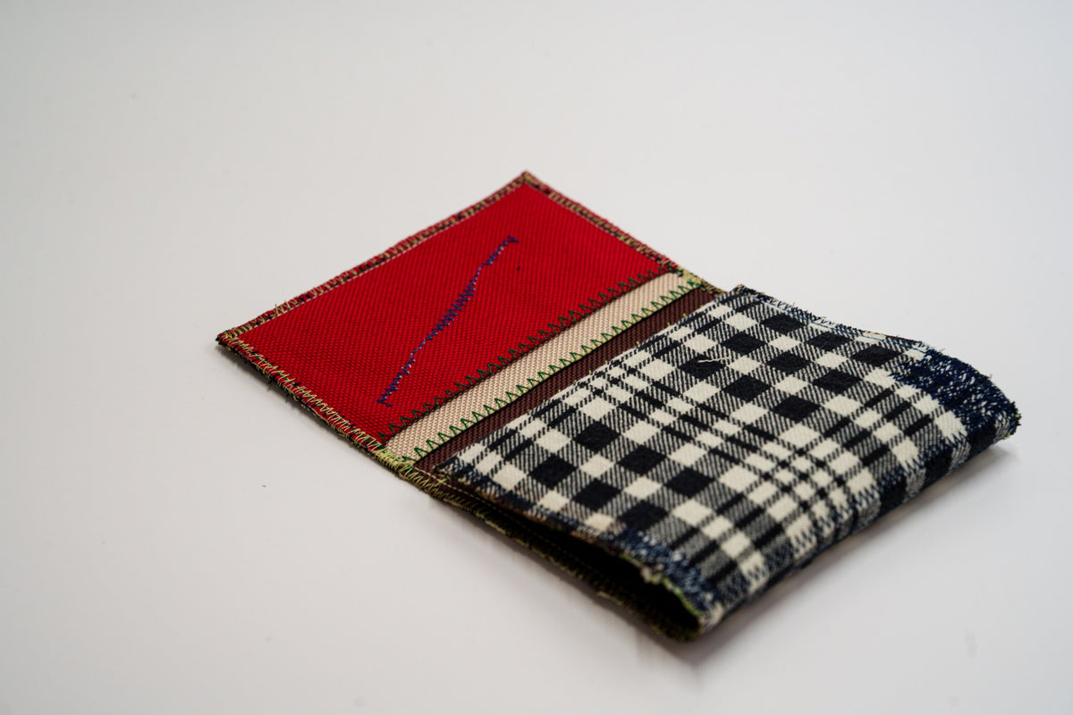 Half-open wallet, red interior card slot meeting the black and pale-olive plaid exterior — HighSew