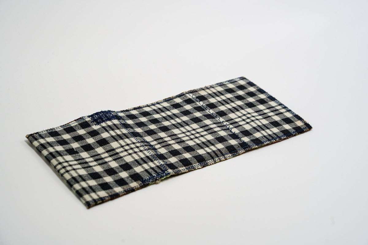 Black and pale-olive plaid exterior of a one-of-a-kind wallet, laid flat — HighSew